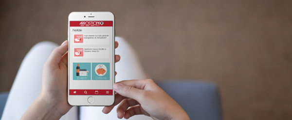 ragazza tiene in mano iphone con mobile app Arrosticini d'Abruzzo